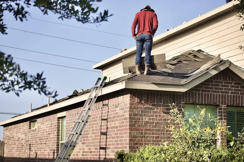 Professional roofer working on a residential roof in Camden Place